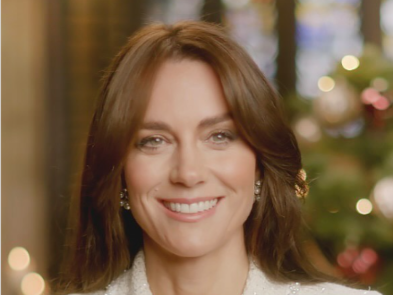 Princess Catherine 'Kate' Middleton sitting in front of a Christmas tree.