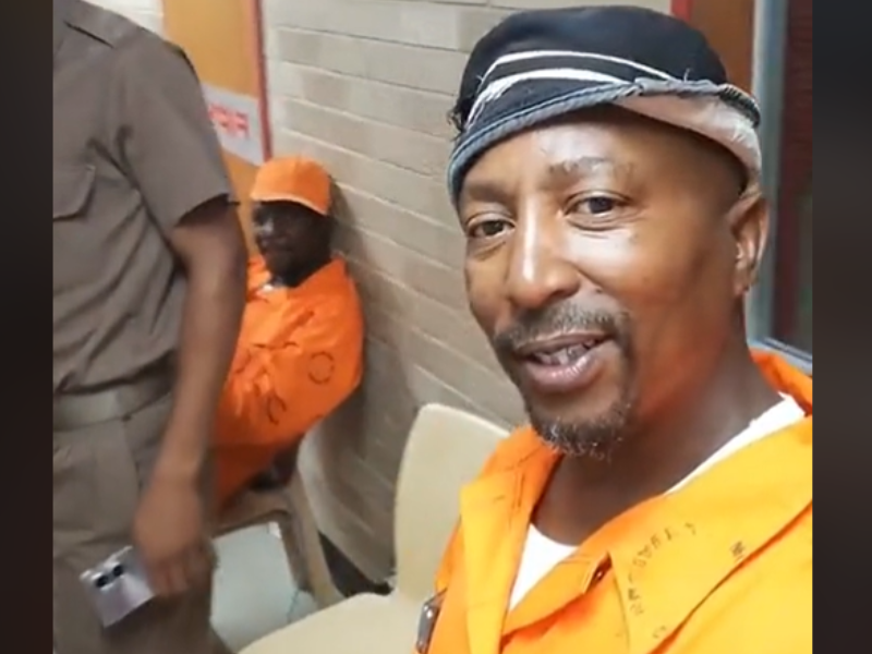 Prisoner videoing himself next to a guard