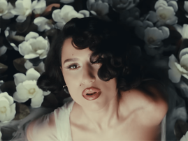 RAYE surrounded by large white flowers