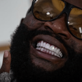 Rick Ross smiling with his diamond cut veneers