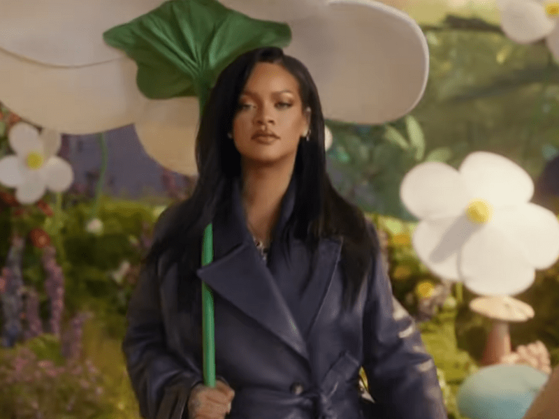Rihanna carrying a giant white flower as an umbrella
