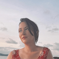 Zelda Williams wears a red dress while posing on a boat