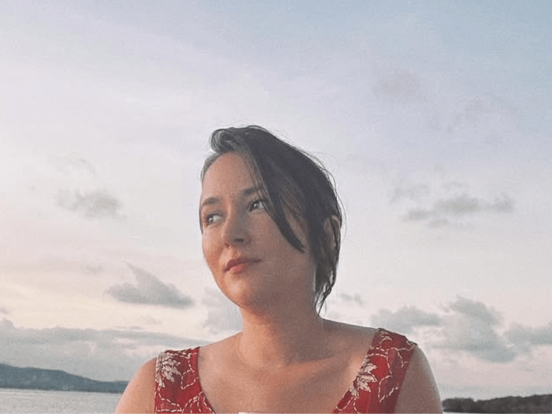 Zelda Williams wears a red dress while posing on a boat