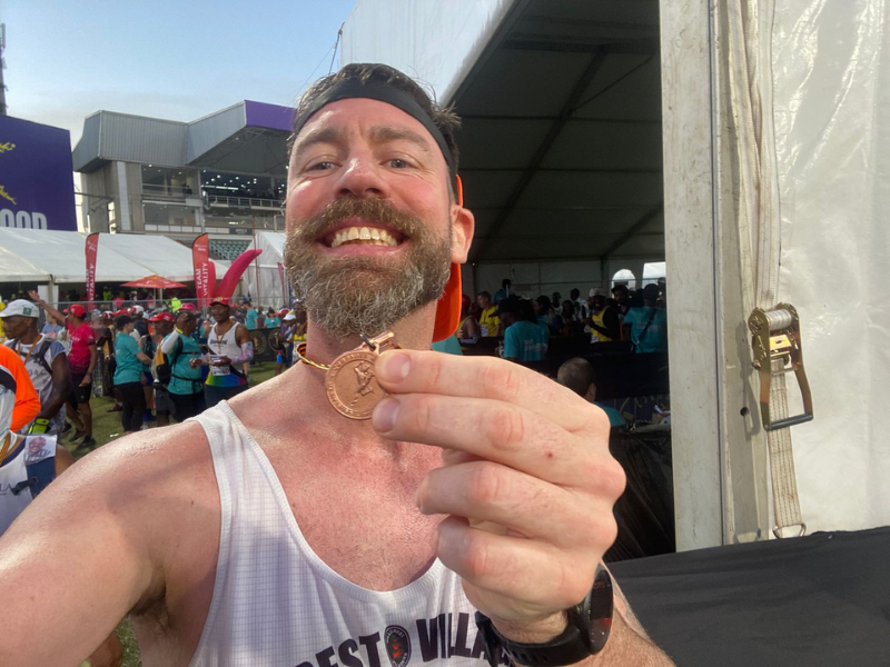 Rory Petzer holding his Comrades Marathon medal