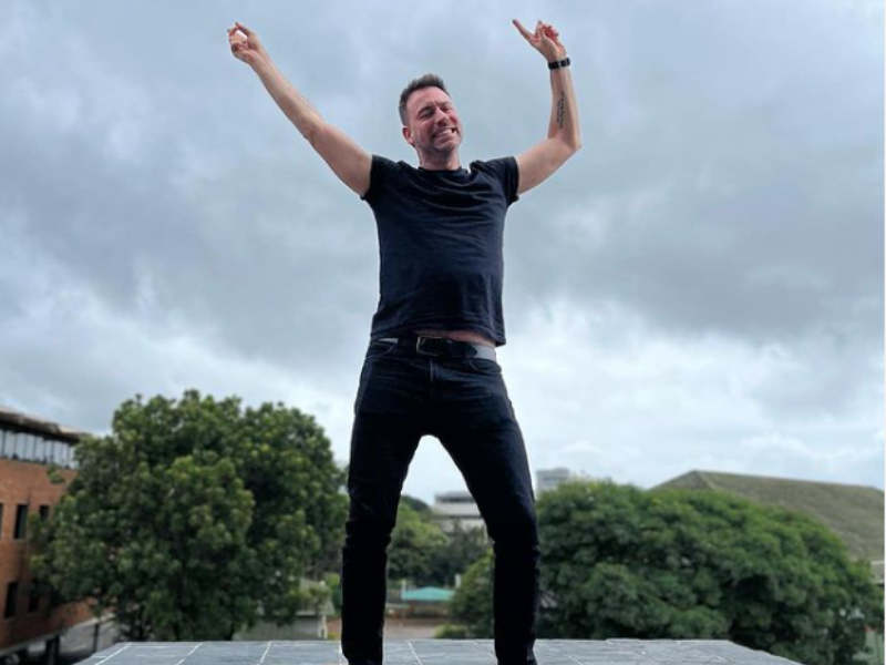 Rory Petzer standing with his arms in the air