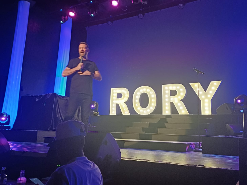 Rory Petzer stands on stage for his solo comedy show
