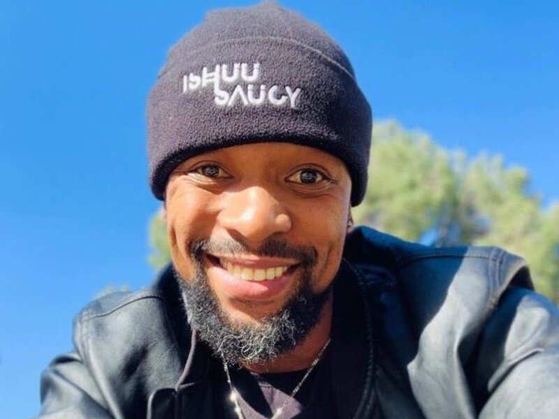 SK Khoza  smiling wearing black beanie hat