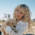 Sabrina Carpenter carrying a golden retriever puppy