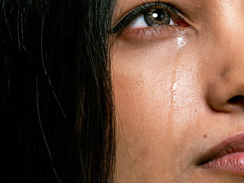 Sad young brown skinned woman crying