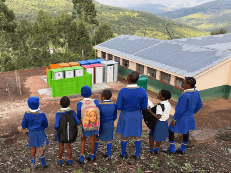 School children looking at newly installed toilets