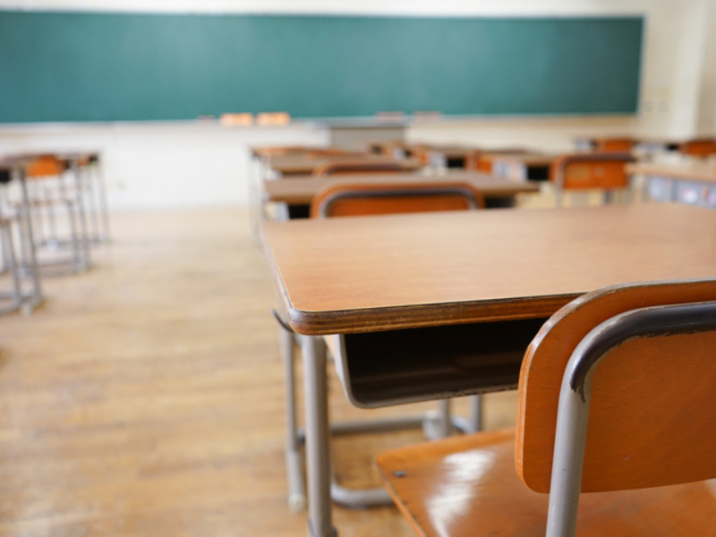 School classroom with empty desks and greenboard