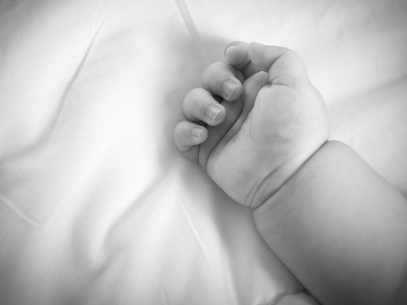 black and white baby with hand only