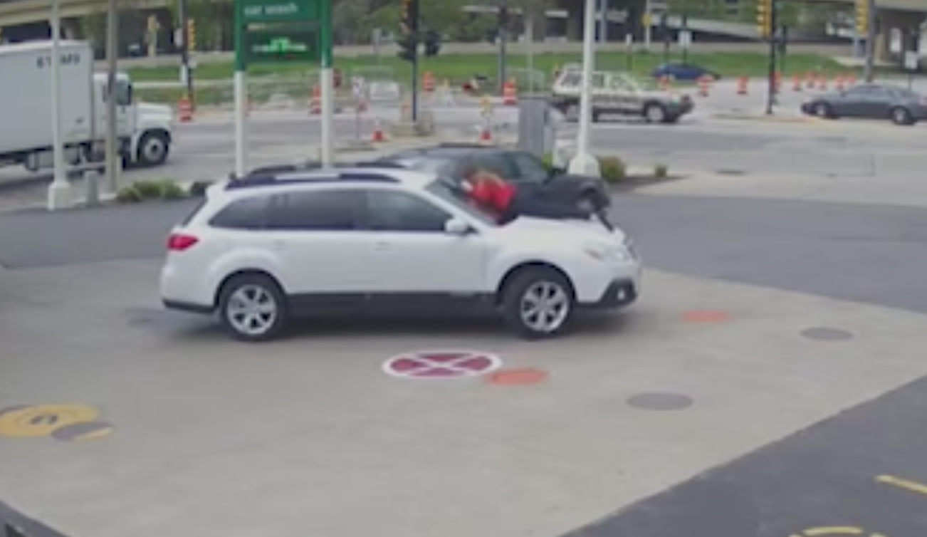 woman jumps on hood of car