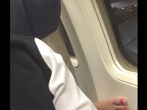 Woman's reaction so sudden appearance of feet on her armrest is priceless!