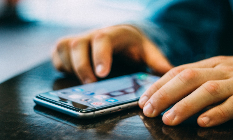 man with phone in hand pexels