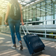 woman walking with luggage pexels