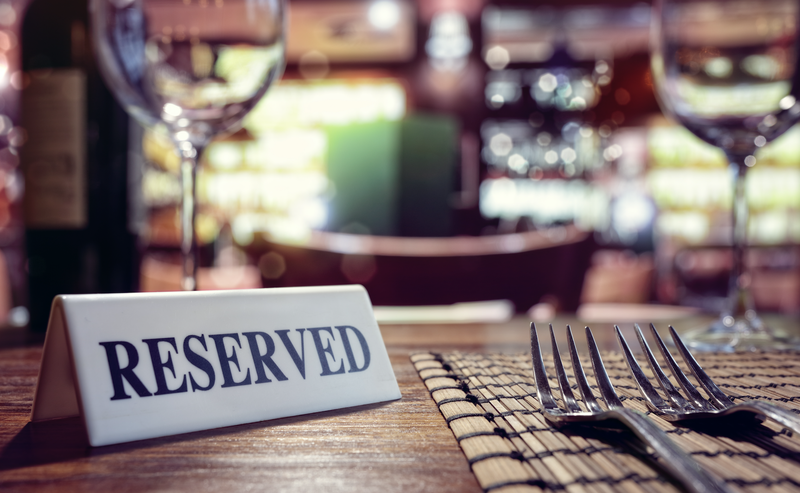 Reserved sign on restaurant table with bar background / iStock