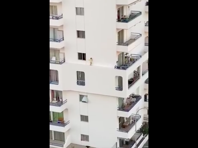Young girl walking on ledge of wall