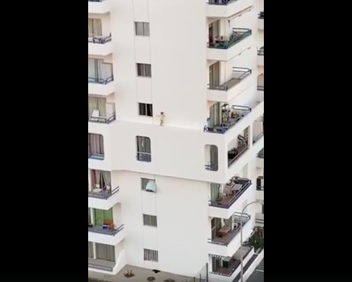 Young girl walking on ledge of wall