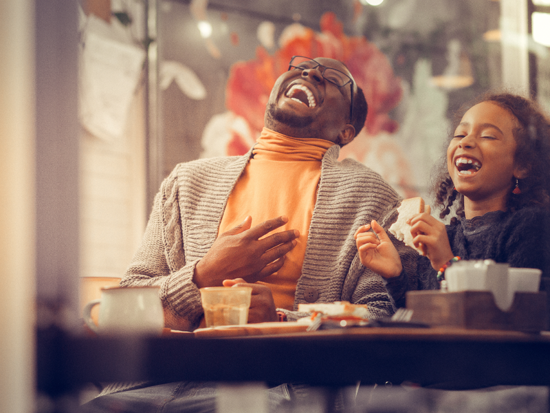 Father and daughter laughing out loud feeling happy together / iStock