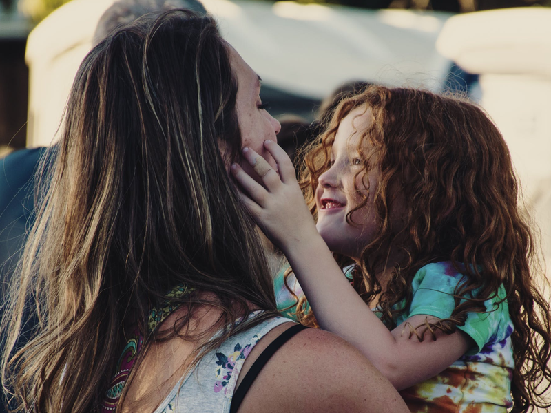 Woman Carrying Girl While Showing Smile / Pexels