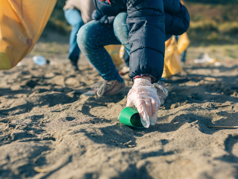Little girl cleaning the beach / iStock