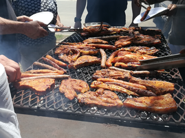 South African people braaing meat together / iStock