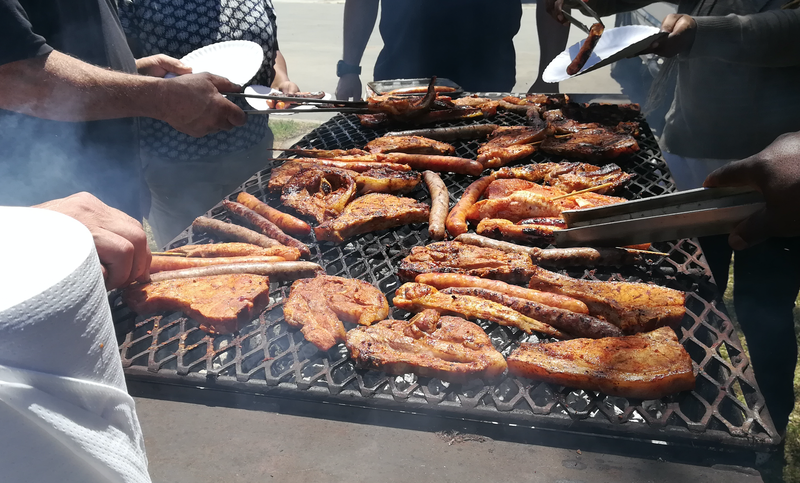 South African people braaing meat together / iStock