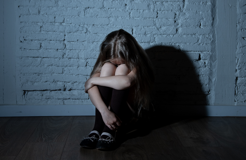 Girl crying in a corner / iStock