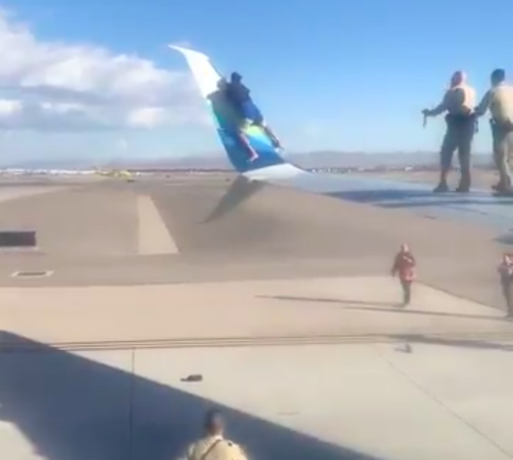 Unruly man climbs onto airplane wing before takeoff