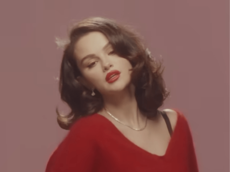 Selena Gomez wearing a red sweater