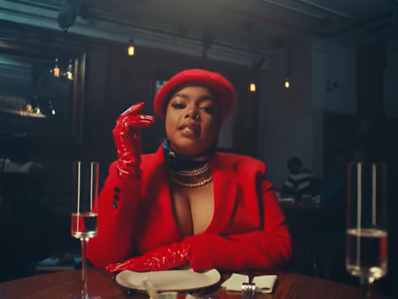 Shekhinah wearing red gloves, a red blazer and French beret