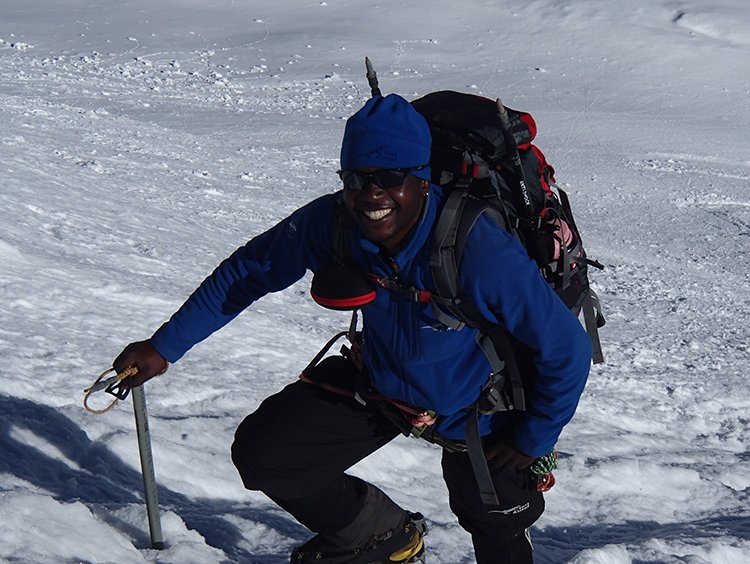 Sibusiso Vilane summitting a snowy mountain