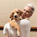 Singer Pink carries a golden coloured puppy