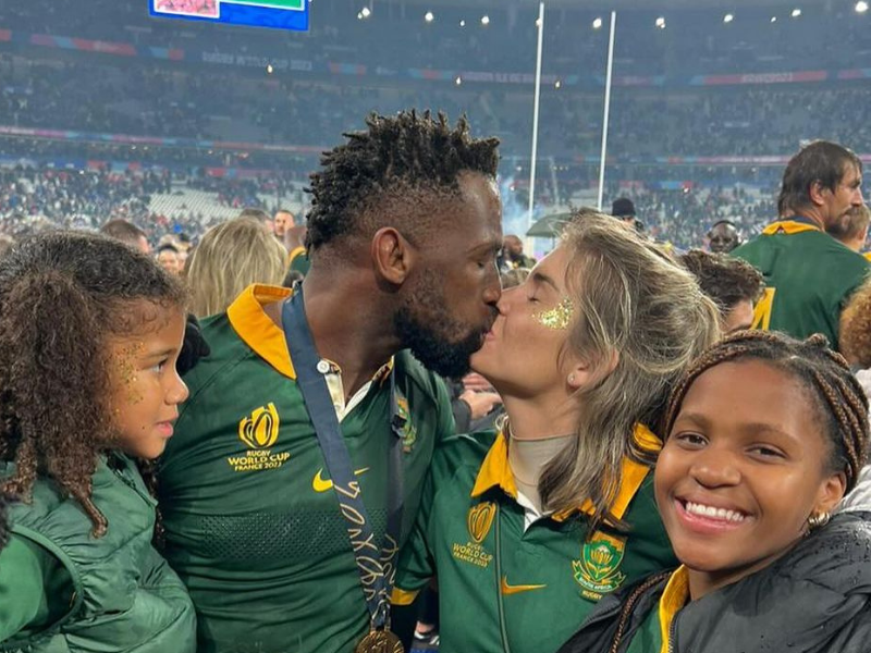 Siya Kolisi kissing Rachel Kolisi at a rugby game