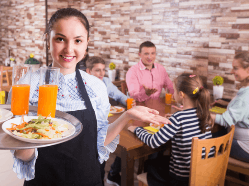 Waitress serving family at restaurant