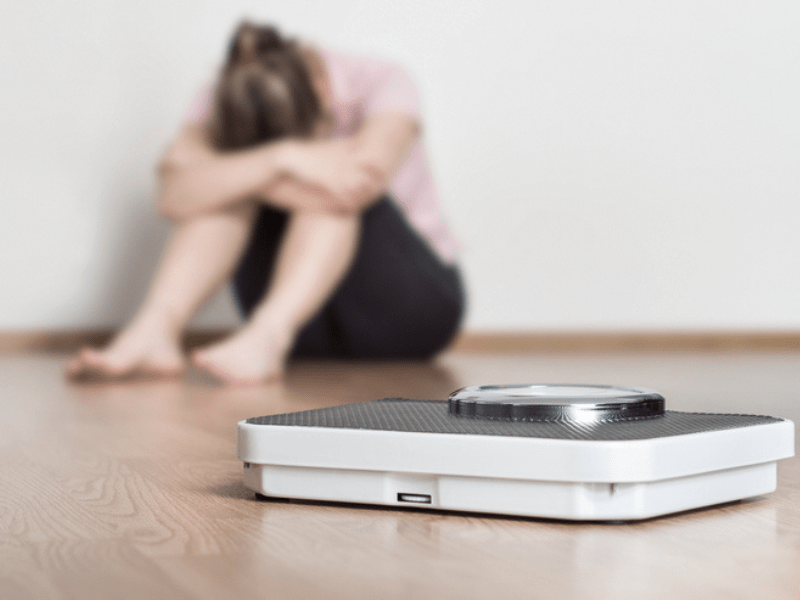 Sad stressed woman sitting on a floor