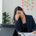 Stressed woman working on a tablet in an office
