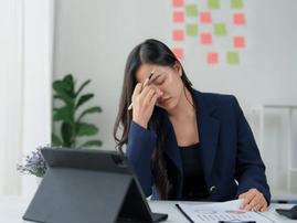 Stressed woman working on a tablet in an office