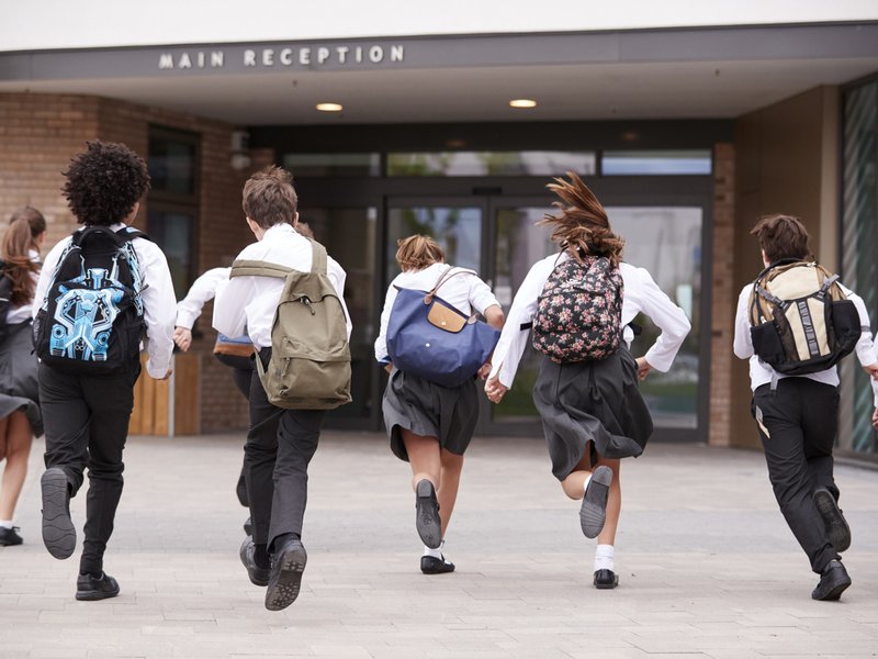 Students Wearing Uniform Running Into School Building