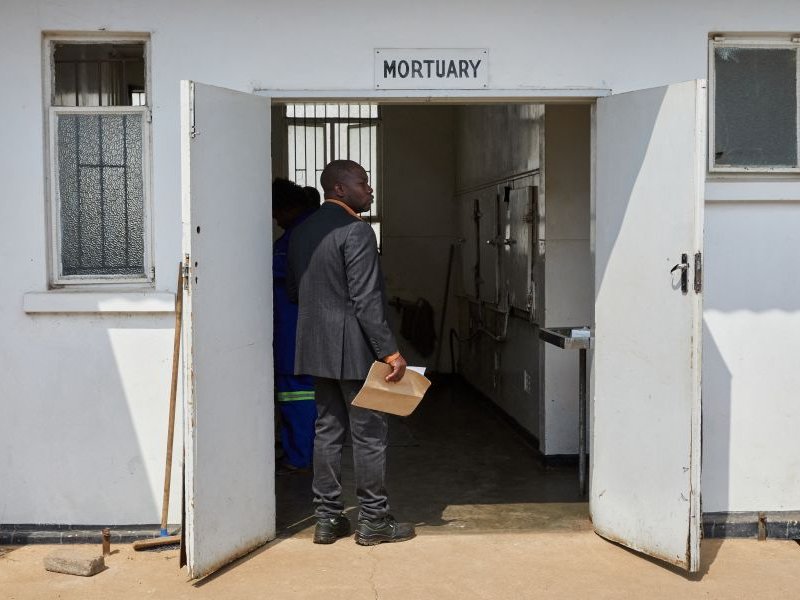 Takemore Malunga holds burial papers for his maternal uncle, a victim of the capsized passenger ferry, at the doorway to Kariba Hospital mortuary in Kariba