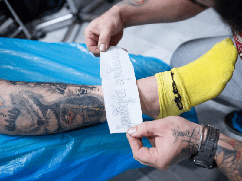Tattoo artist preparing man leg for a tattoo