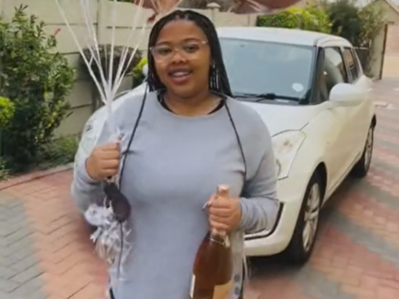 Teenager holding balloons and a bottle of alcohol