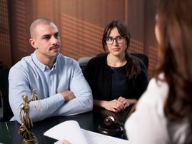 A couple sitting in front of lawyer