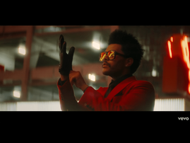 The Weeknd wearing a red suit in Blinding Lights