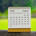 The month of August 2025 on a calendar with green blurred background