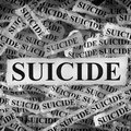 Torn pieces of paper with the words Suicide
