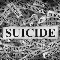 Torn pieces of paper with the words Suicide