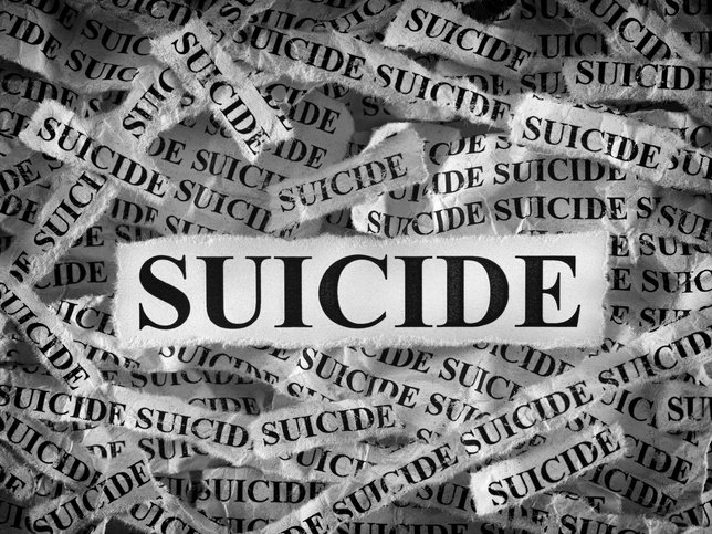 Torn pieces of paper with the words Suicide