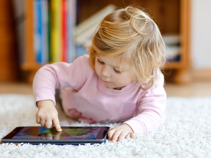 Toddler girl playing with tablet